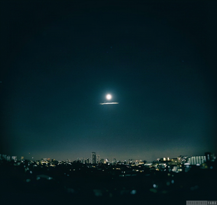 夜空の真ん中に満月、満月の下に線を引いたような雲がでている