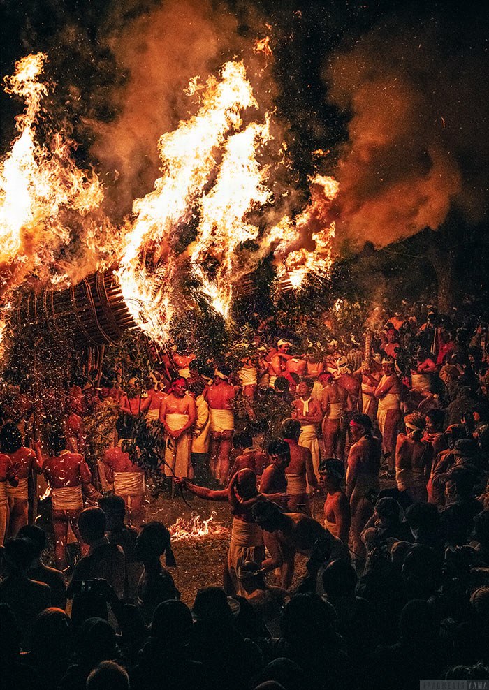 吹き上がった火と照らされる祭りの男性たち
